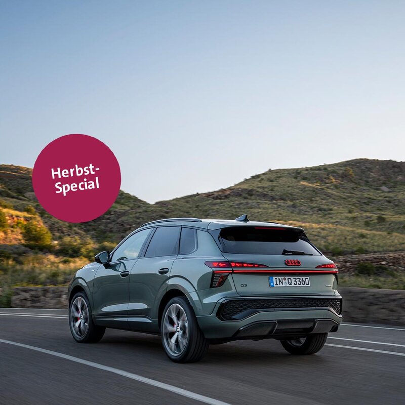 Audi Q3 fährt auf einer Landstraße durch bergige Landschaft bei Sonnenuntergang – Herbst-Special Angebot