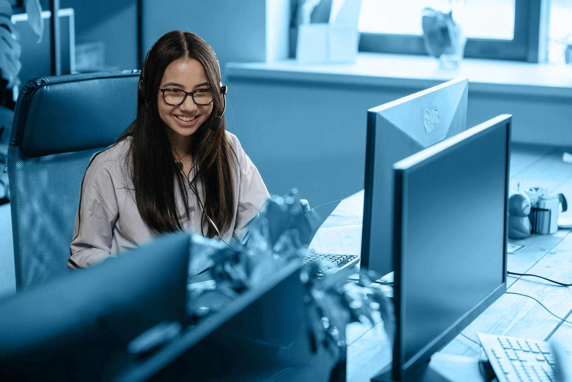 Junge Frau sitzt an einem Schreibtisch vor einem Computer